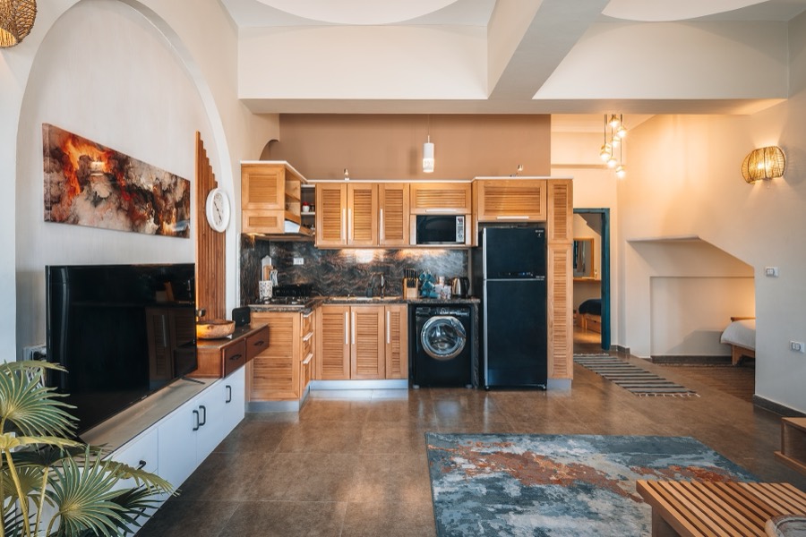 Open kitchen with wooden cabinetry and stone floor