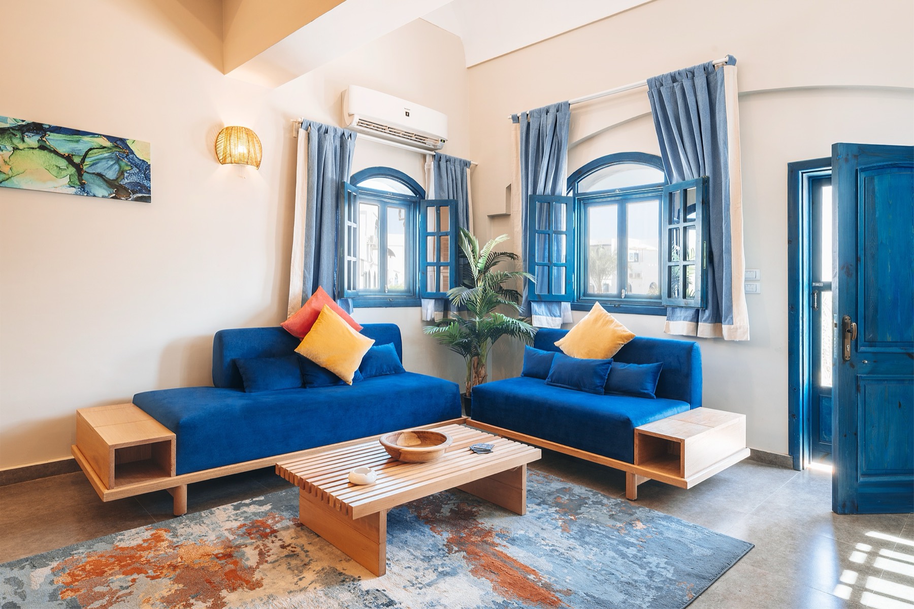 Living room with cobalt velvet sofas and arched blue windows