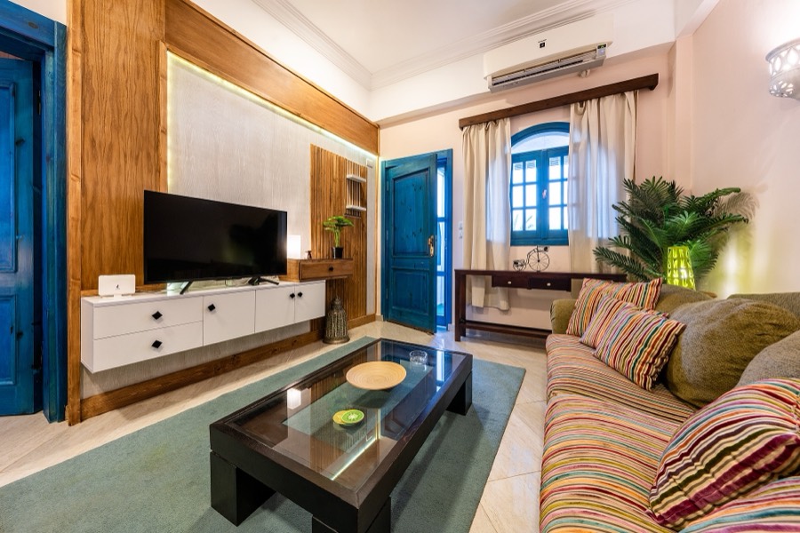 Living room with teal doors and a wall-mounted television