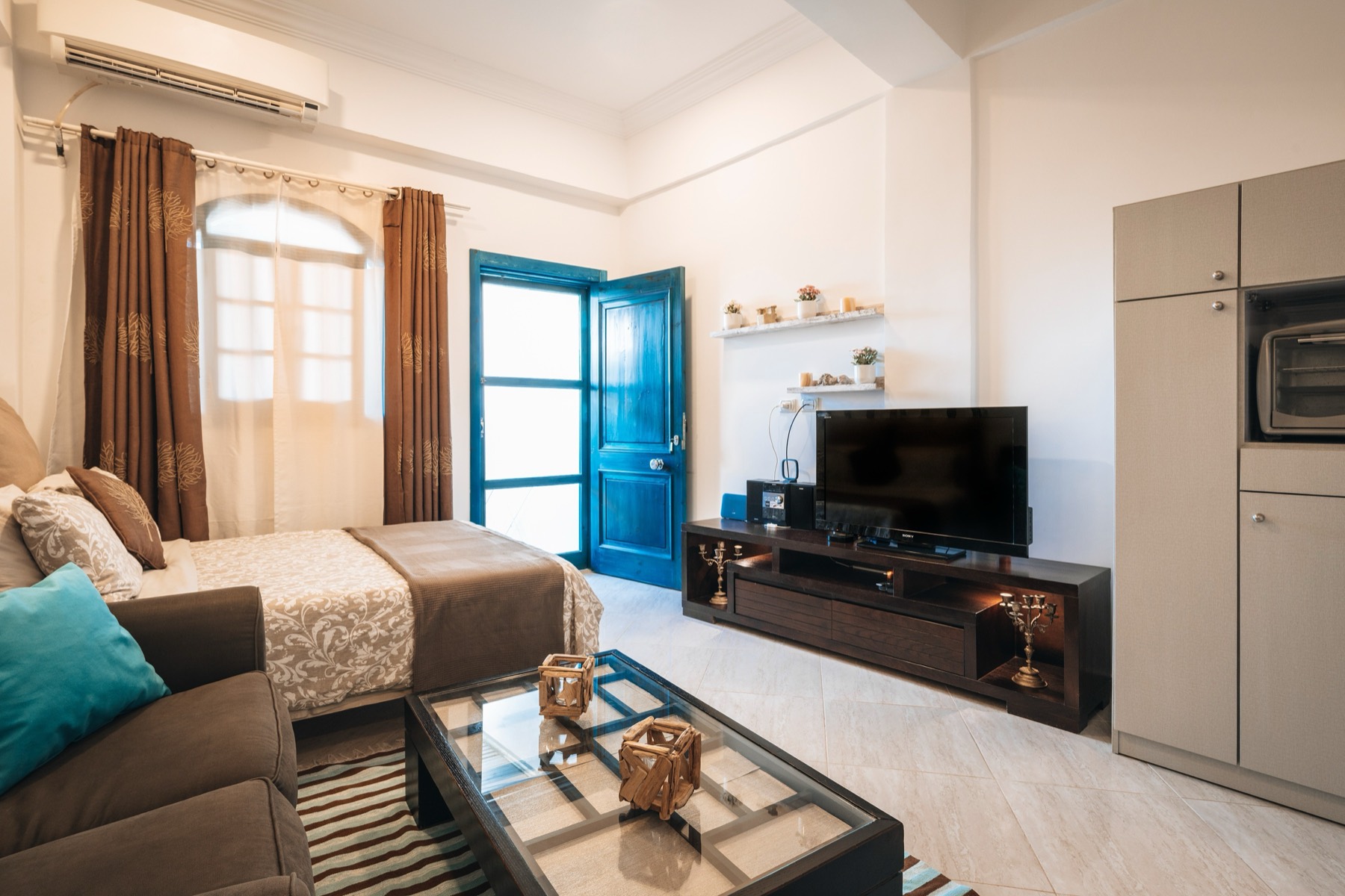 Studio living area with blue door and sofa